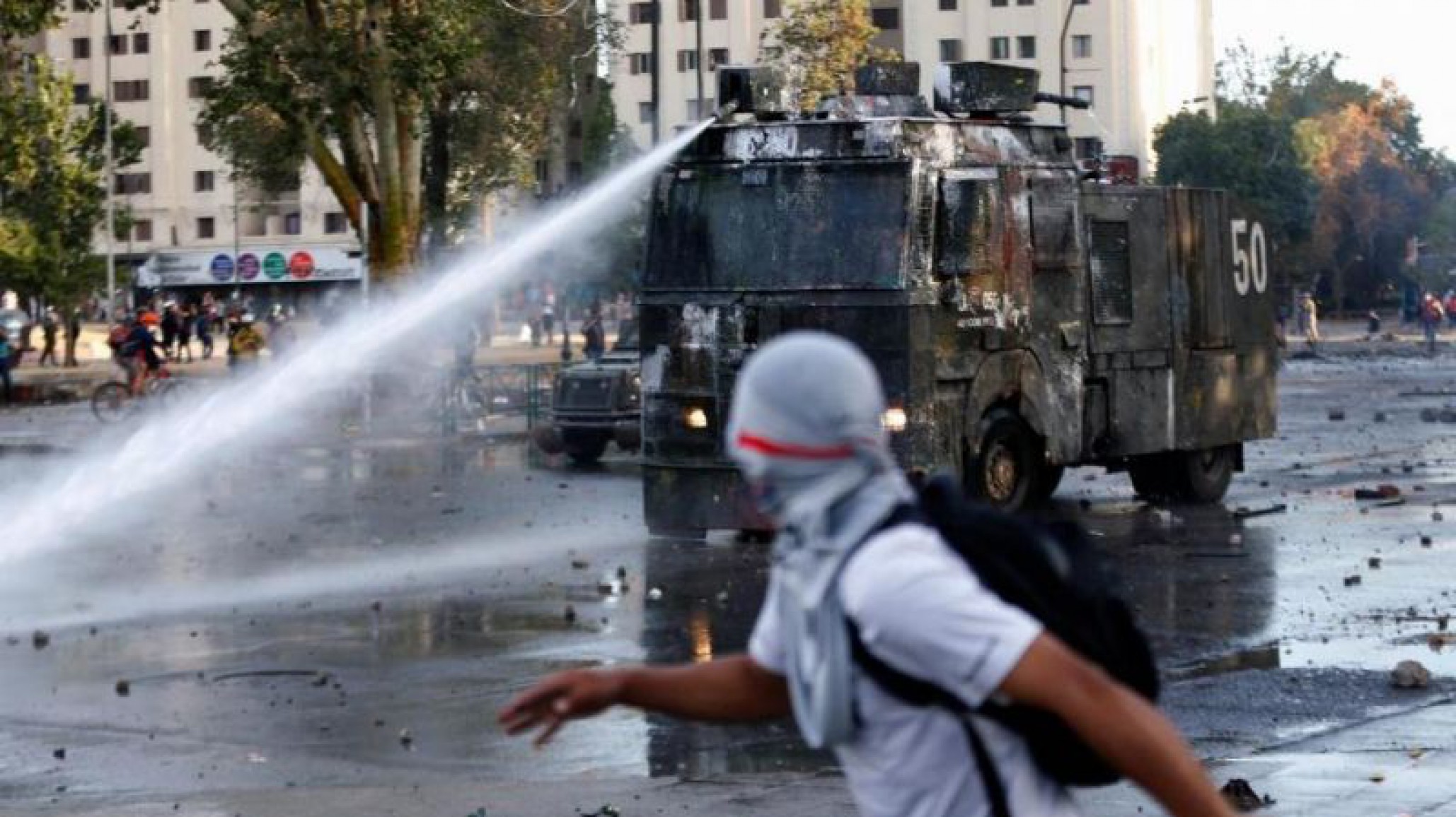 Manifestante se sube a camión hidrante para romperlo