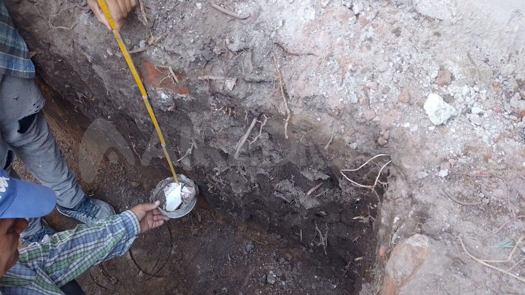 Cavaron para una pileta y hallaron restos óseos en vasija, platos y una botella