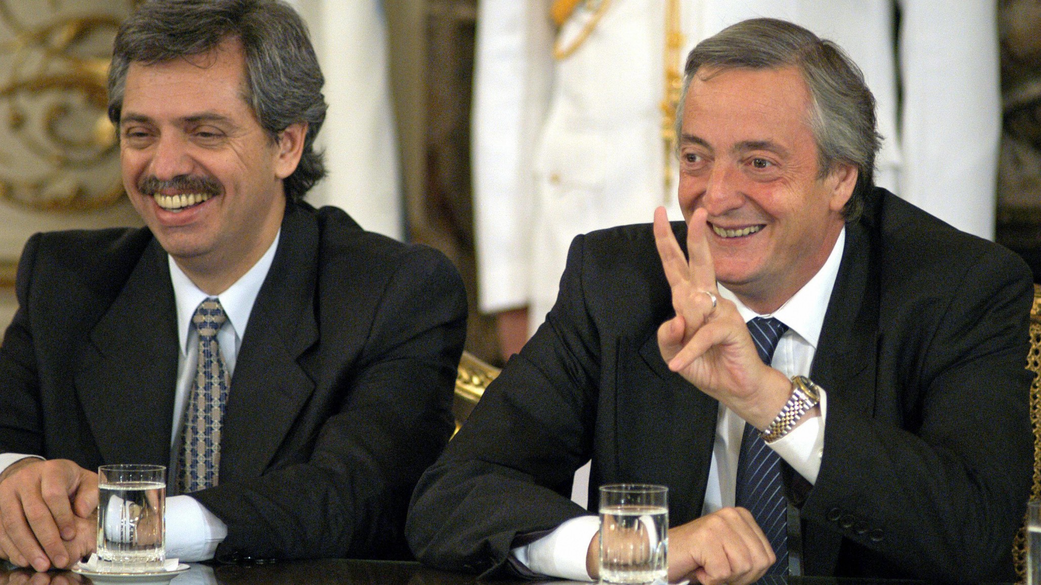 <p>BUENOS AIRES, ARGENTINA: Argentinean President Nestor Kirchner makes the V sign next to Chief of Cabinet Alberto Fernandez 10 March, 2004 during a ceremony at the Presidential Palace in Buenos Aires. IMF and Argentine authorities had struck a deal on